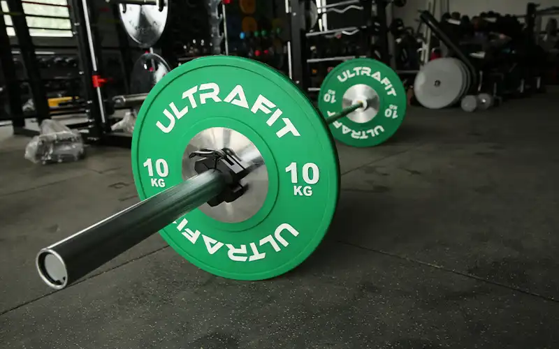 Olympic barbell bar loaded with weight plates on a gym platform